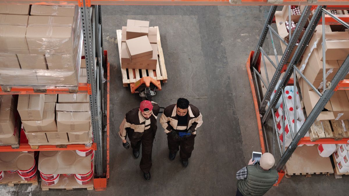 Encargado revisando el inventario de varias sucursales de un comercio desde una tablet.