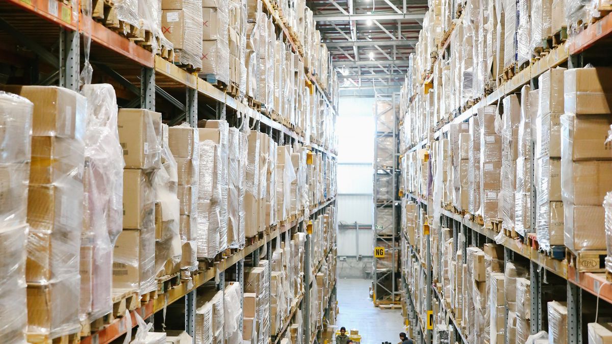 Almacén de distribución farmacéutica con estantería y cajas de medicamento.