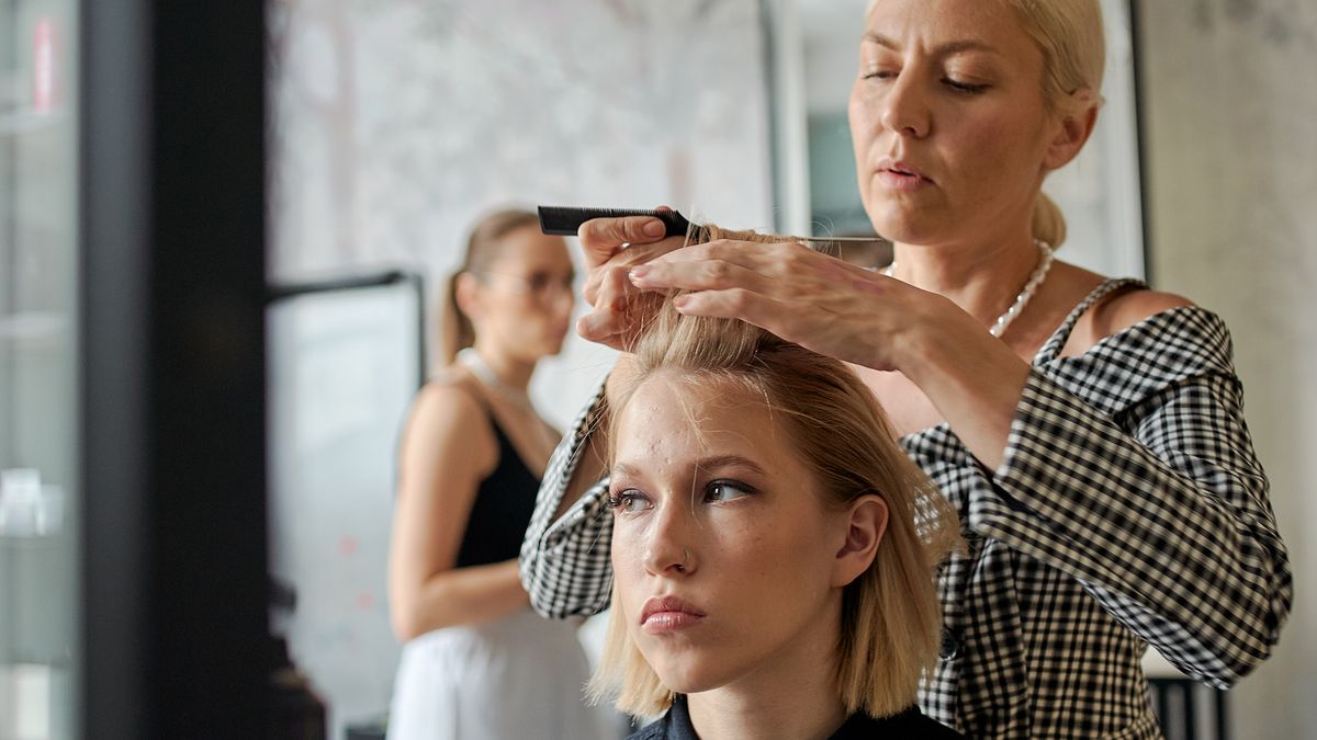 Profesional de belleza atendiendo a una clienta en su salón.